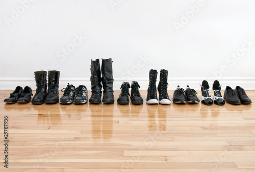 Tableau sur toile Row of shoes and boots on a wooden floor