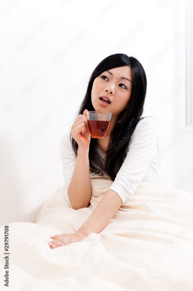 beautiful asian woman drinking tea on the bed beautiful asian woman drinking tea on the bed