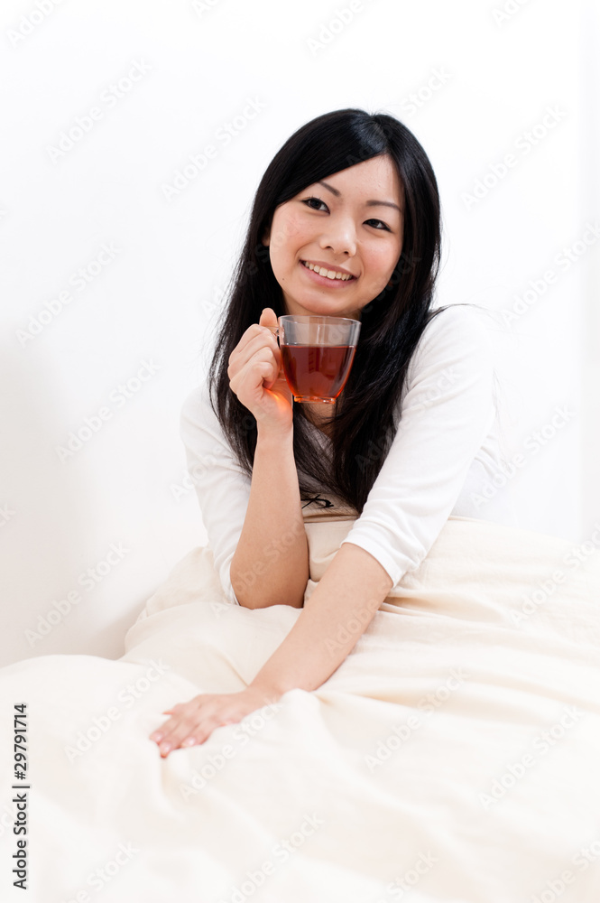 beautiful asian woman drinking tea on the bed beautiful asian woman drinking tea on the bed