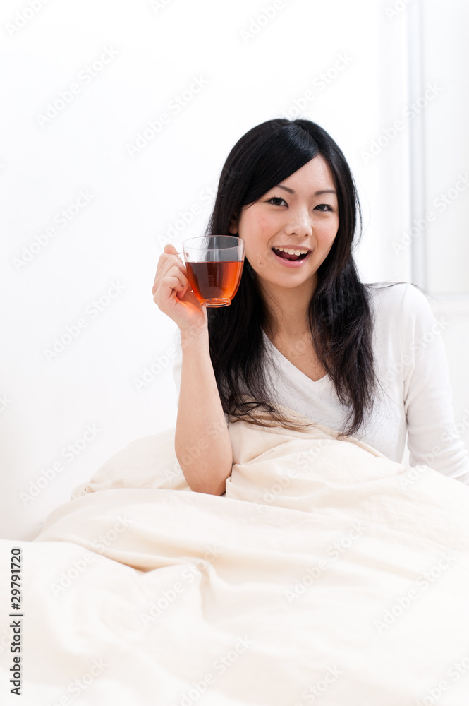 beautiful asian woman drinking tea on the bed beautiful asian woman drinking tea on the bed