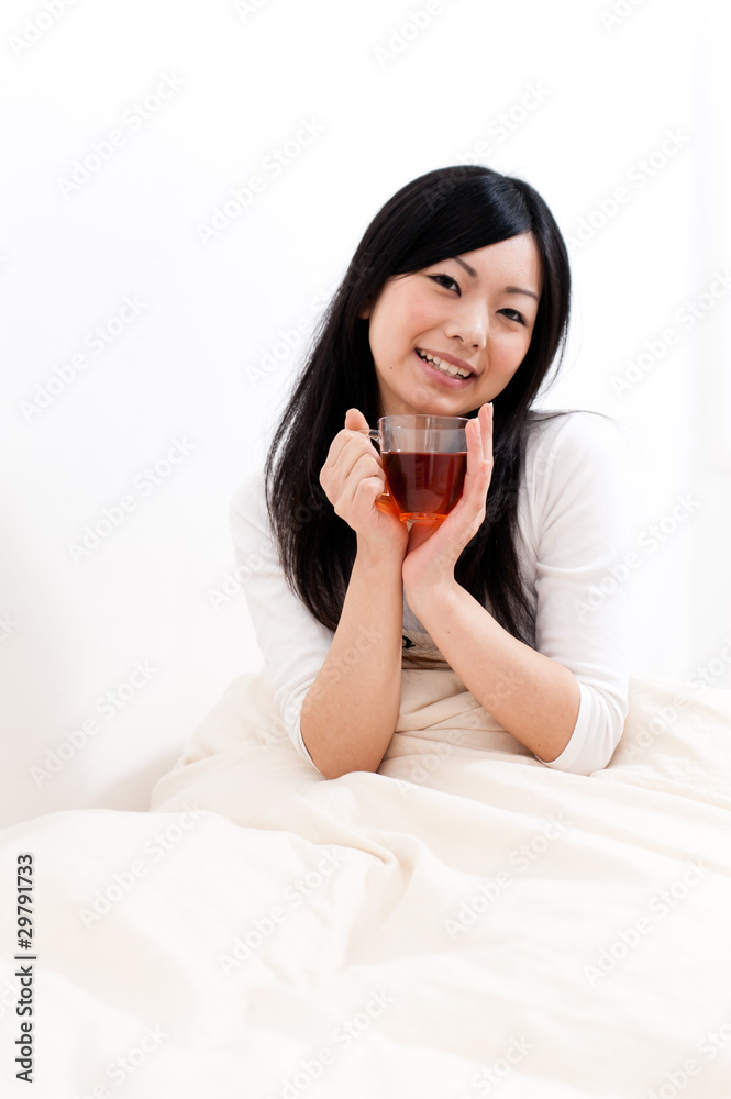 beautiful asian woman drinking tea on the bed beautiful asian woman drinking tea on the bed