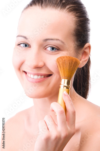 woman is applying powder on her face