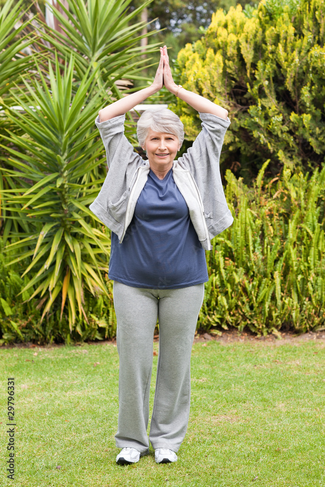 Mature woman doing her streches in the garden