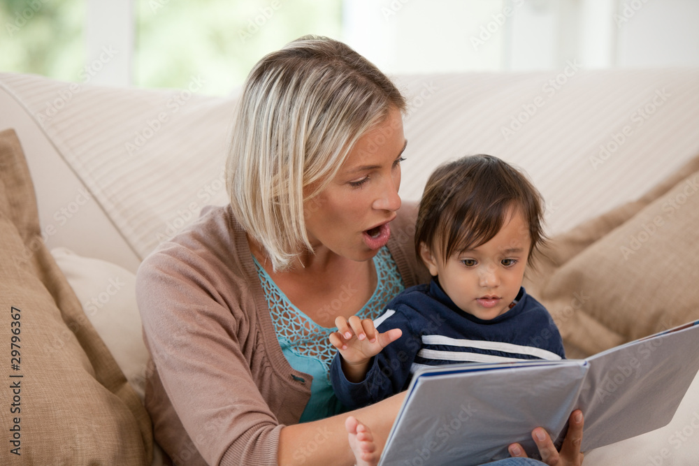 Mother looking at a book with her son Mother looking at a book with her son