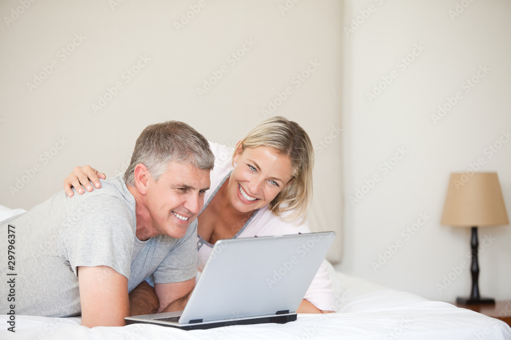 Lovely couple looking at their laptop