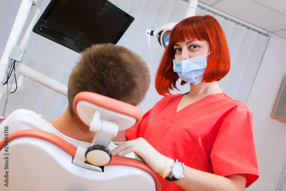 Image of young lady with dentist over her checking oral cavity . Image of young lady with dentist over her checking oral cavity .
