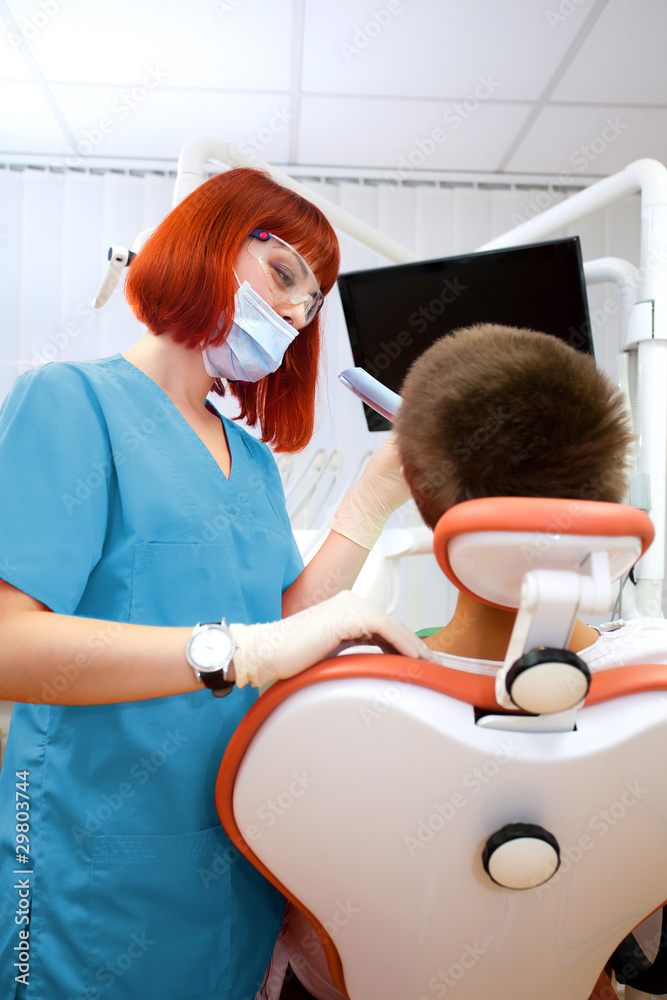 Obraz premium Image of young lady with dentist over her checking oral cavity .