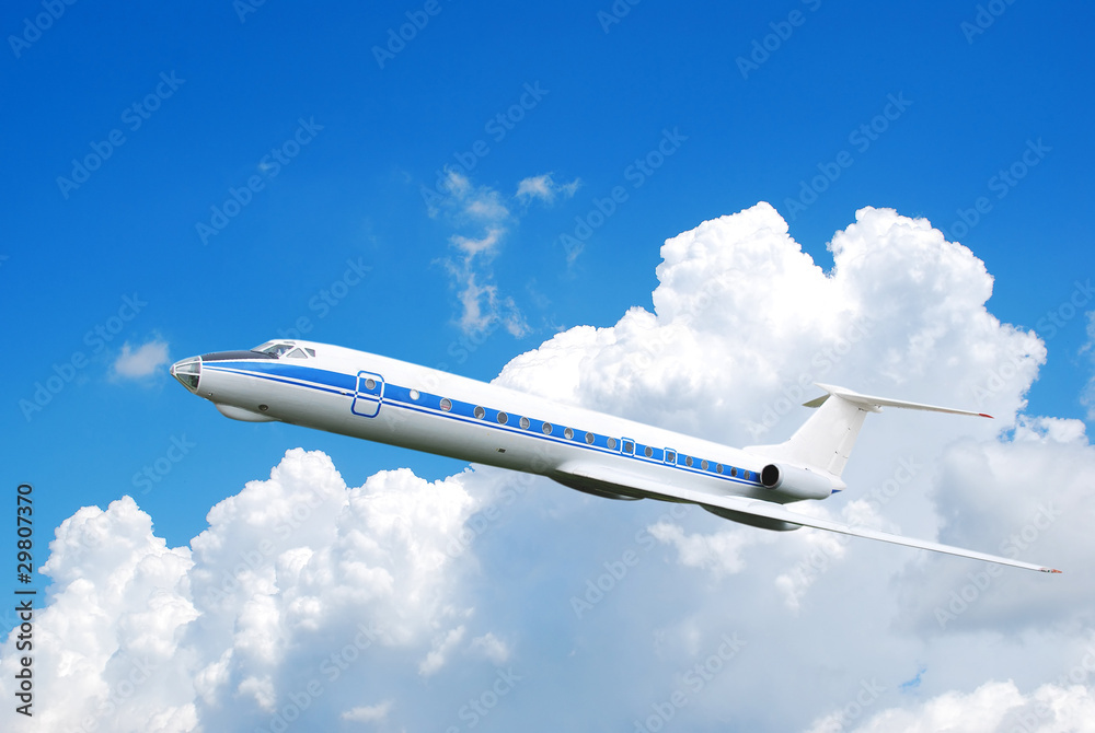 Flying jet airplane against blue cloudy sky Flying jet airplane against blue cloudy sky