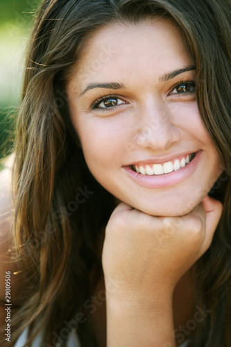 Young happy girl with long hair posing outdoor.