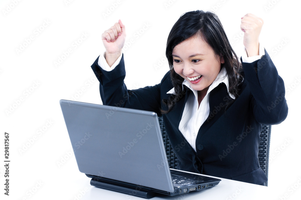 Happy young businesswoman cheering in front of laptop Happy young businesswoman cheering in front of laptop