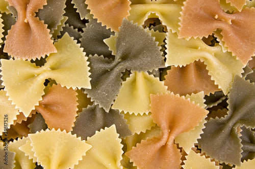 close up of uncooked multi-colored bow pasta
