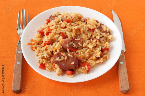 rice with sausages and pepper on an white plate