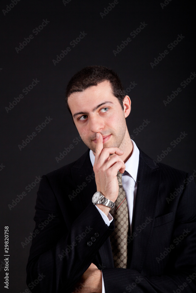 Thoughtful young businessman isolated on black Thoughtful young businessman isolated on black