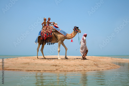 Two children ride a camel