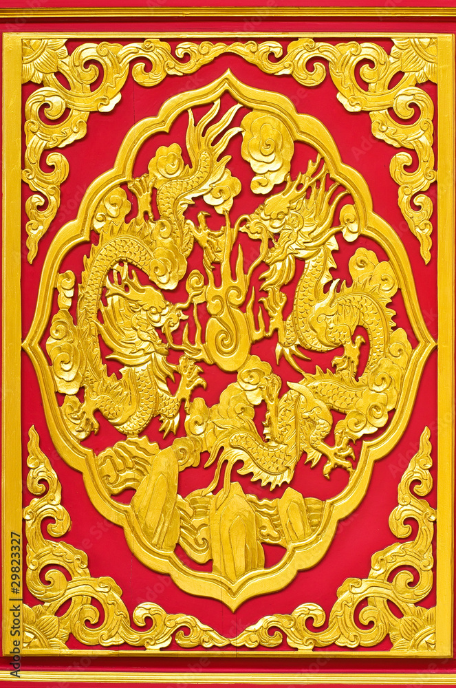 Golden dragon statue on the red wall of Chinese temple