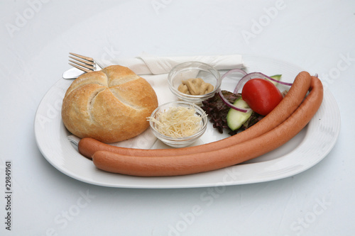 Vienna sausages with bread and salad on a white background