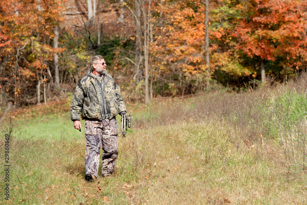 bowhunter scouting the woodline