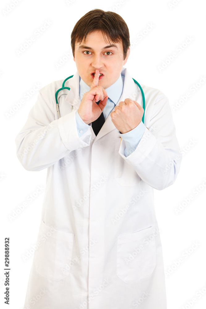 Angry doctor with finger at mouth and threaten with fist Angry doctor with finger at mouth and threaten with fist