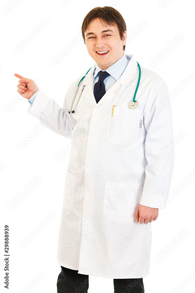 Smiling medical doctor pointing finger at something Smiling medical doctor pointing finger at something
