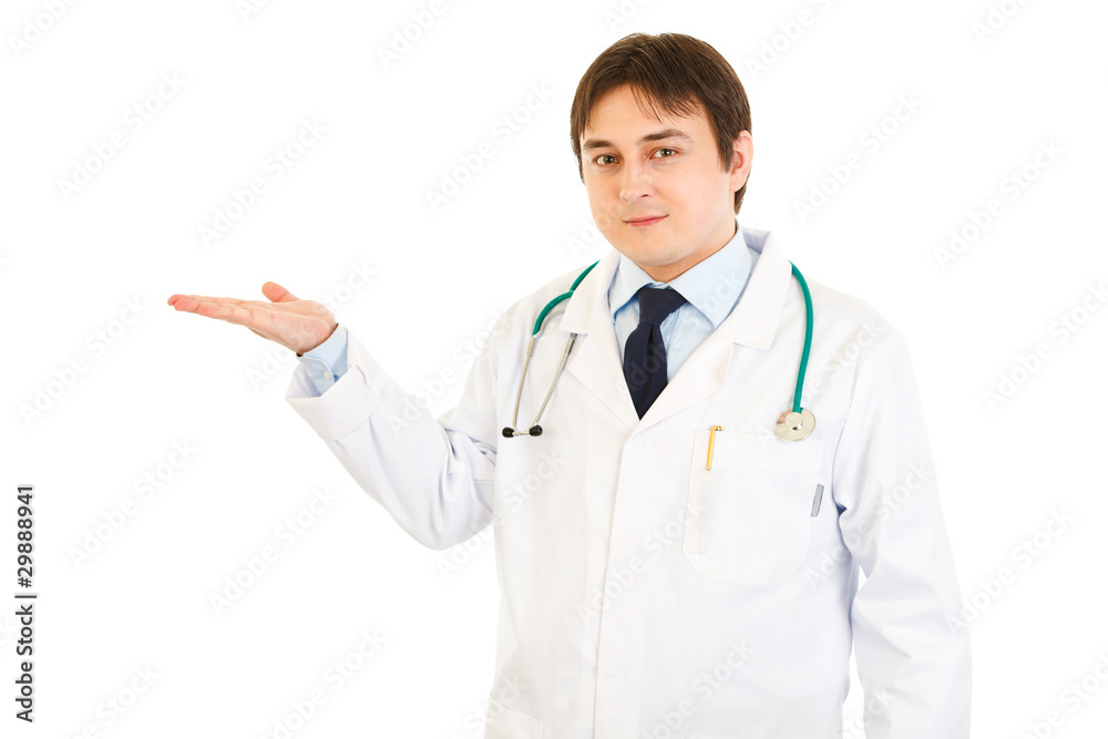 Smiling medical doctor presenting something on empty hand Smiling medical doctor presenting something on empty hand