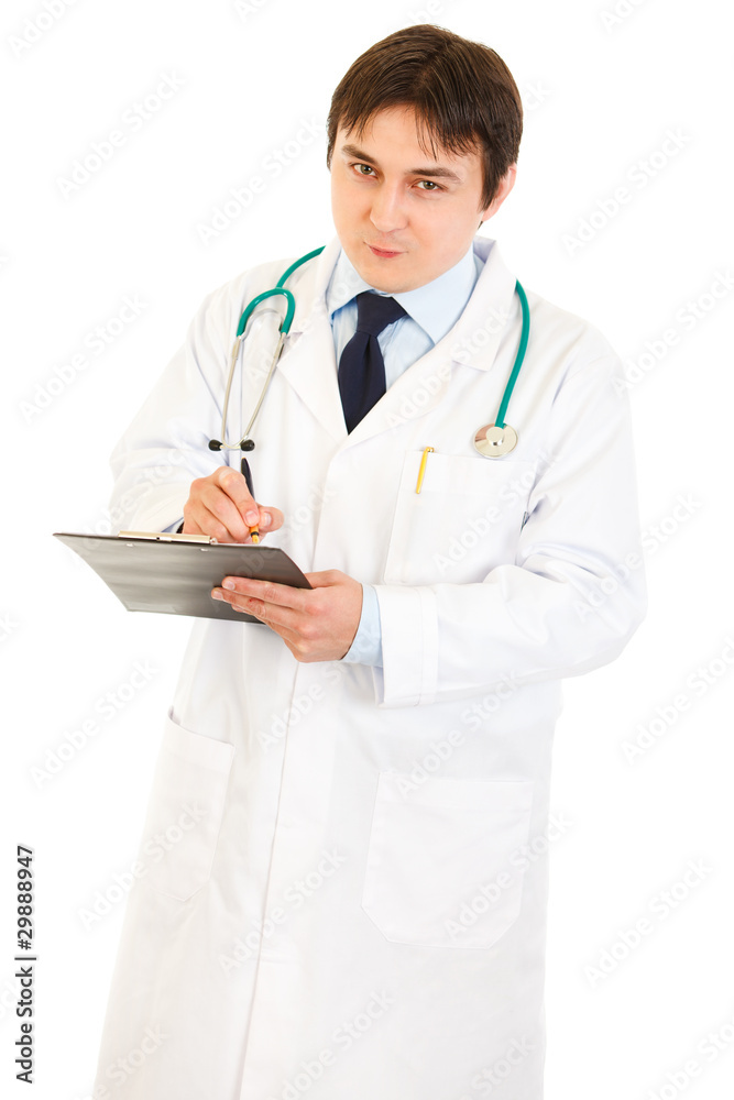 Smiling doctor with stethoscope making notes in medical chart Smiling doctor with stethoscope making notes in medical chart
