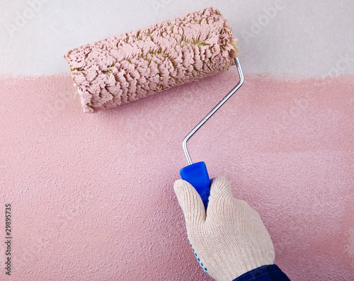 house painter using a paint roller, painting a wall in motion photo