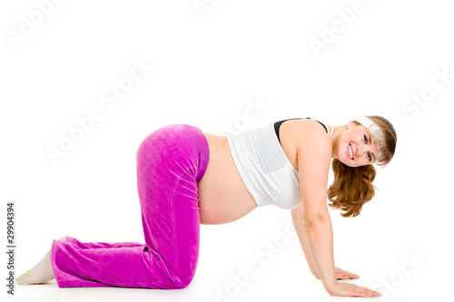 Smiling beautiful pregnant woman doing fitness exercises