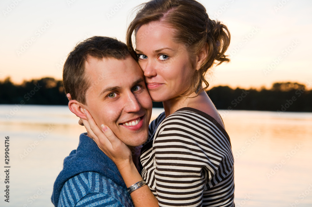 young attractive couple near lake at sunset young attractive couple near lake at sunset