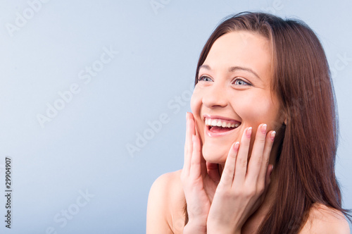 happy beautiful woman is looking sideways. Isolated on blue back