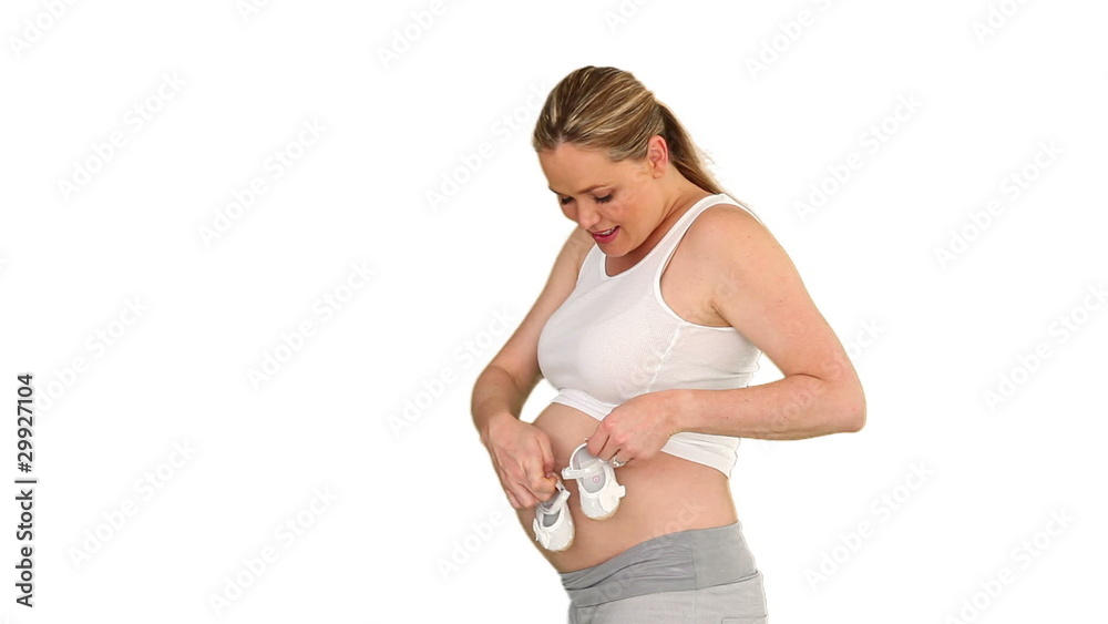 Attractive pregnant woman playing with the shoes Attractive pregnant woman playing with the shoes