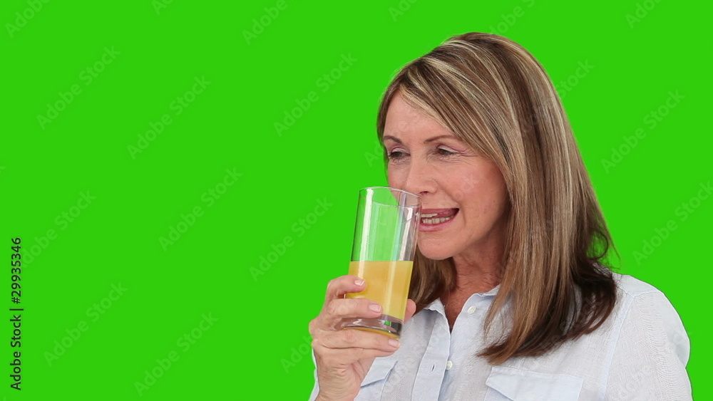 Senior woman drinking a glass of orange juice Senior woman drinking a glass of orange juice