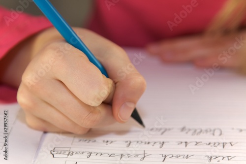 Kinderhand schreibt mit Bleistift close photo