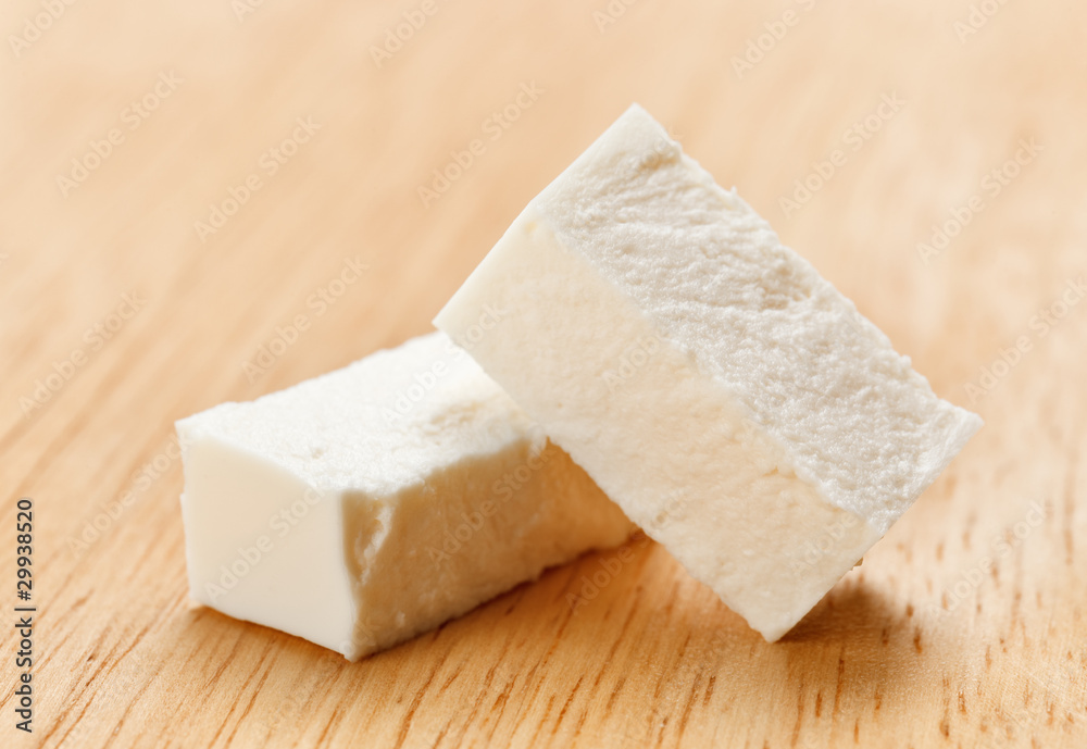Feta cheese cubes with on wooden chopping board
