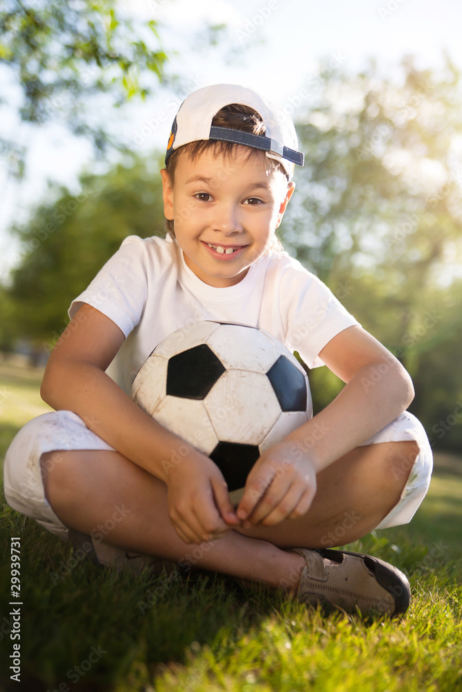 Cute little boy with a ball in beautiful park in nature Cute little boy with a ball in beautiful park in nature