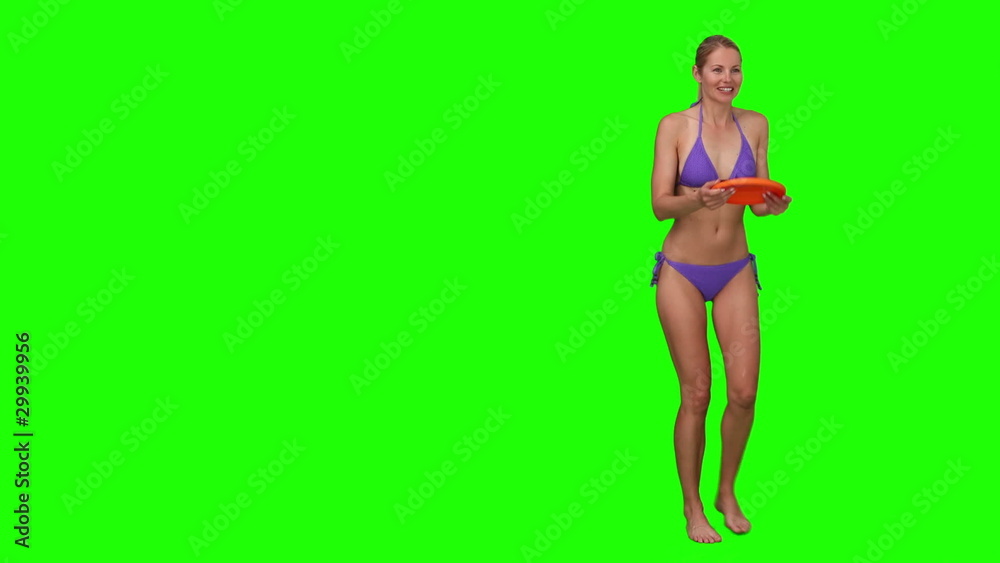 Pretty woman in purple swimsuit playing with a frisby Pretty woman in purple swimsuit playing with a frisby