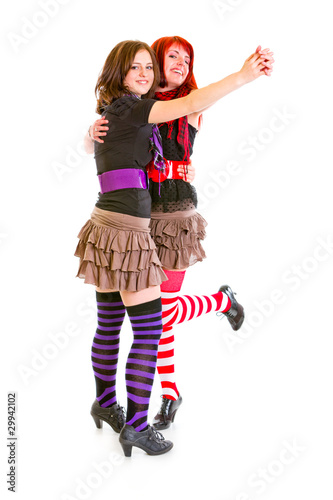 Two cheerful young girlfriends dancing for fun