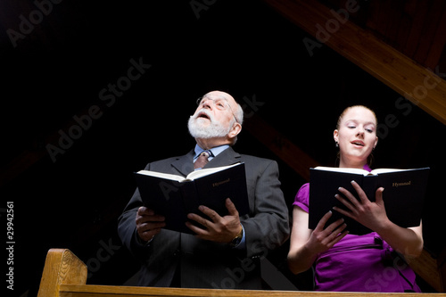 Senior White Man Young Woman Singing Church Hymnal photo