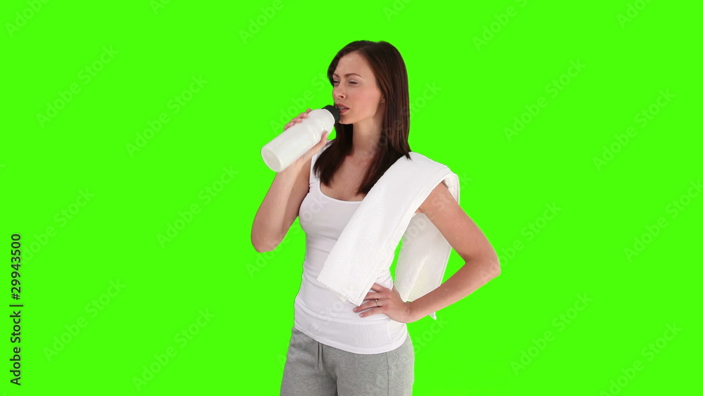 Brunette woman after sport is drinking water Brunette woman after sport is drinking water