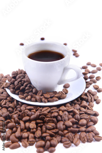 Cup with coffee and beams. Focus on coffee beans