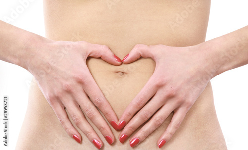Love - A woman's hands forming a heart symbol on belly.
