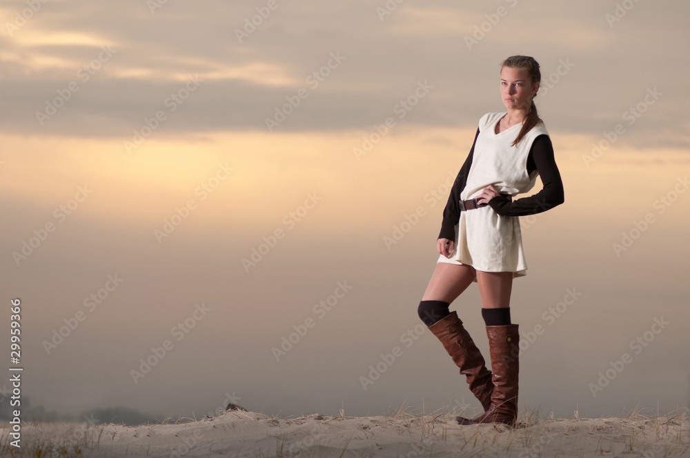 Beautiful young lonely woman walking on sea coast Beautiful young lonely woman walking on sea coast