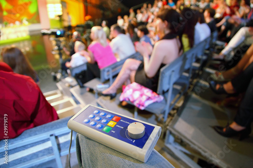 Fotografie Voting device lies on knee in auditorium on television broadcast