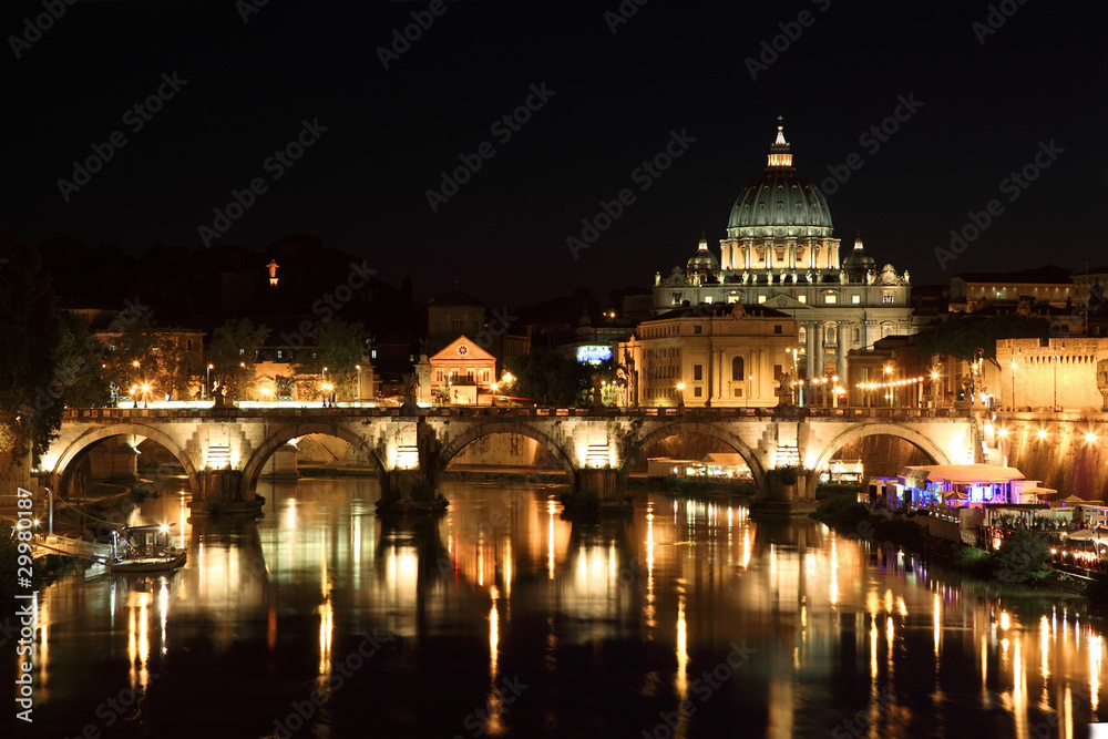 Sant' Angelo Bridge and Basilica of St. Peter at night in Rome,