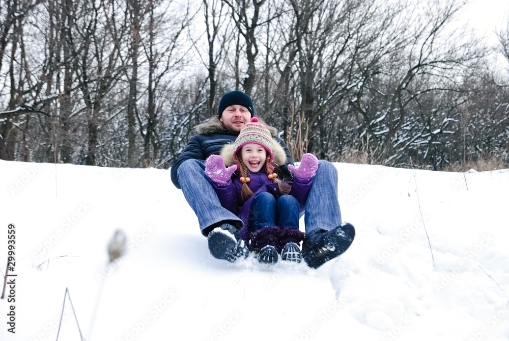 father and daughter riding on a sledge