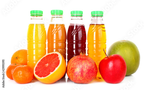 bottles of juice with ripe fruits on white background