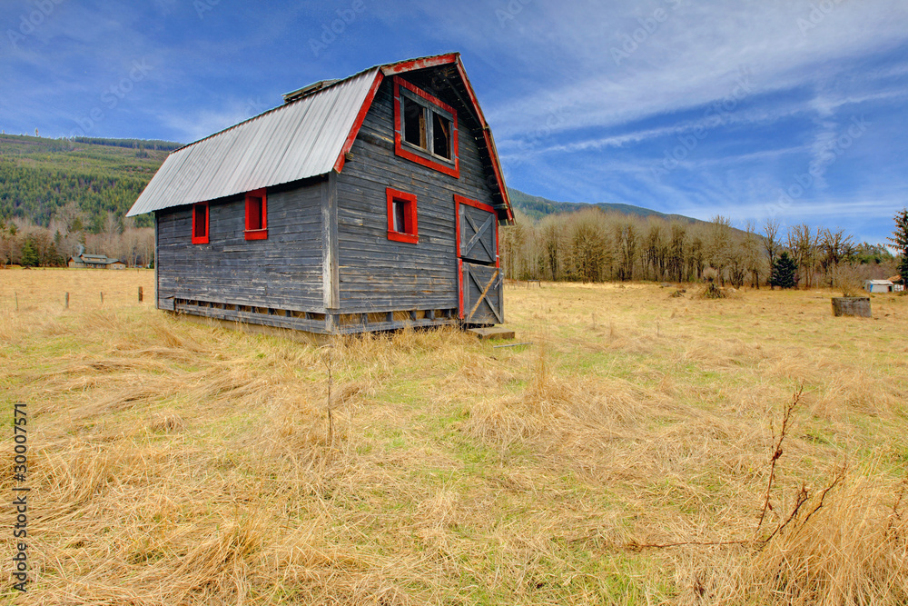 Cute grey and red rustic old barn in the fieild Cute grey and red rustic old barn in the fieild