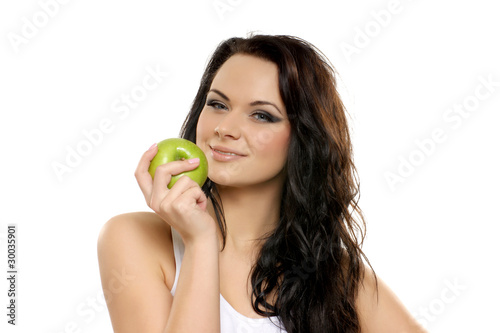 Portrait of a young brunette holding a fresh green apple