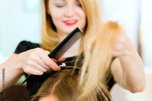 Frau bei Friseurin erhält Haarschnitt