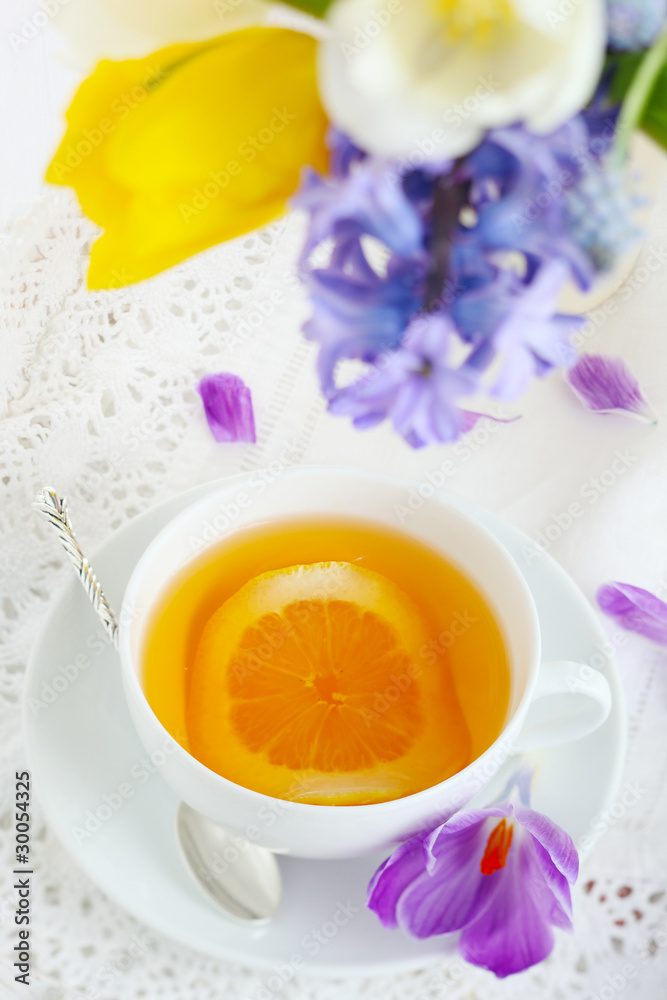 cup of tea with lemon and spring flowers close up cup of tea with lemon and spring flowers close up