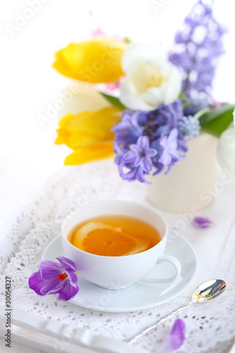cup of tea with lemon and spring flowers  soft focus